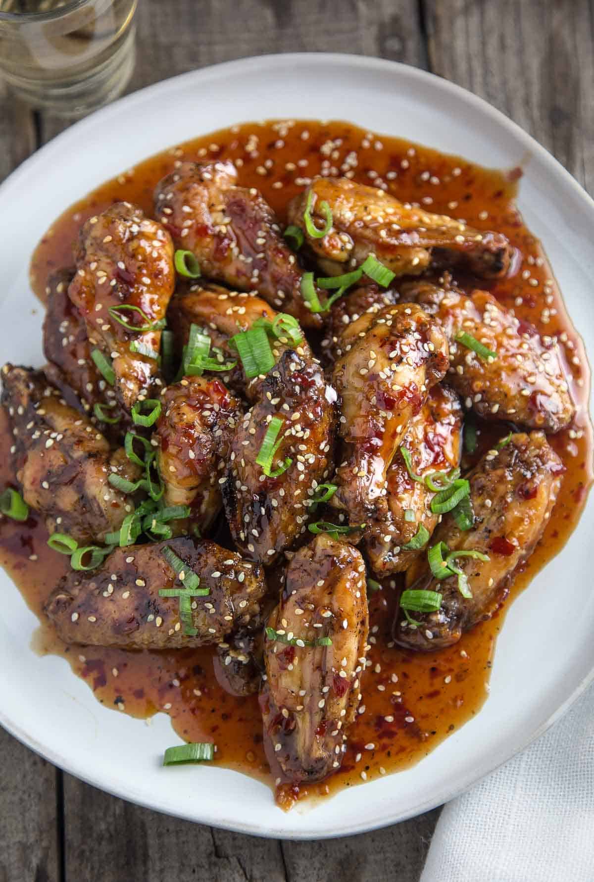 Smoked Chicken Wings with an Asian Thai Chili Sauce on a platter with a glass of wine