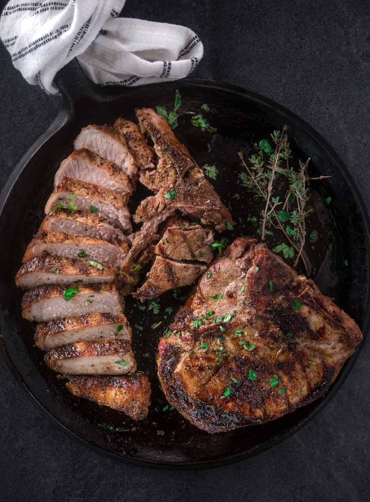Two grilled pork steaks on a serving platter