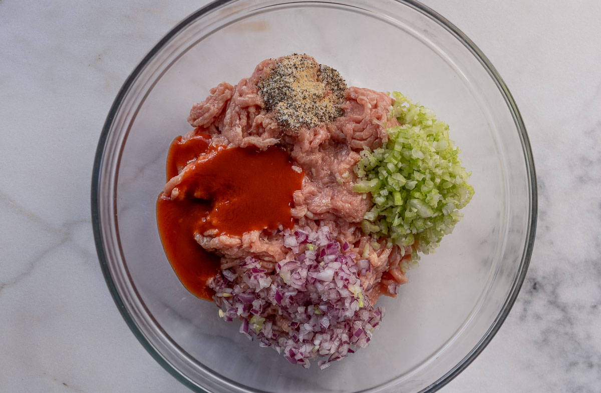 Ingredients in a bowl for Buffalo chicken meatballs before being combined.