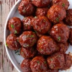 BBQ turkey meatballs that are on a plate with a red wine BBQ sauce glaze.