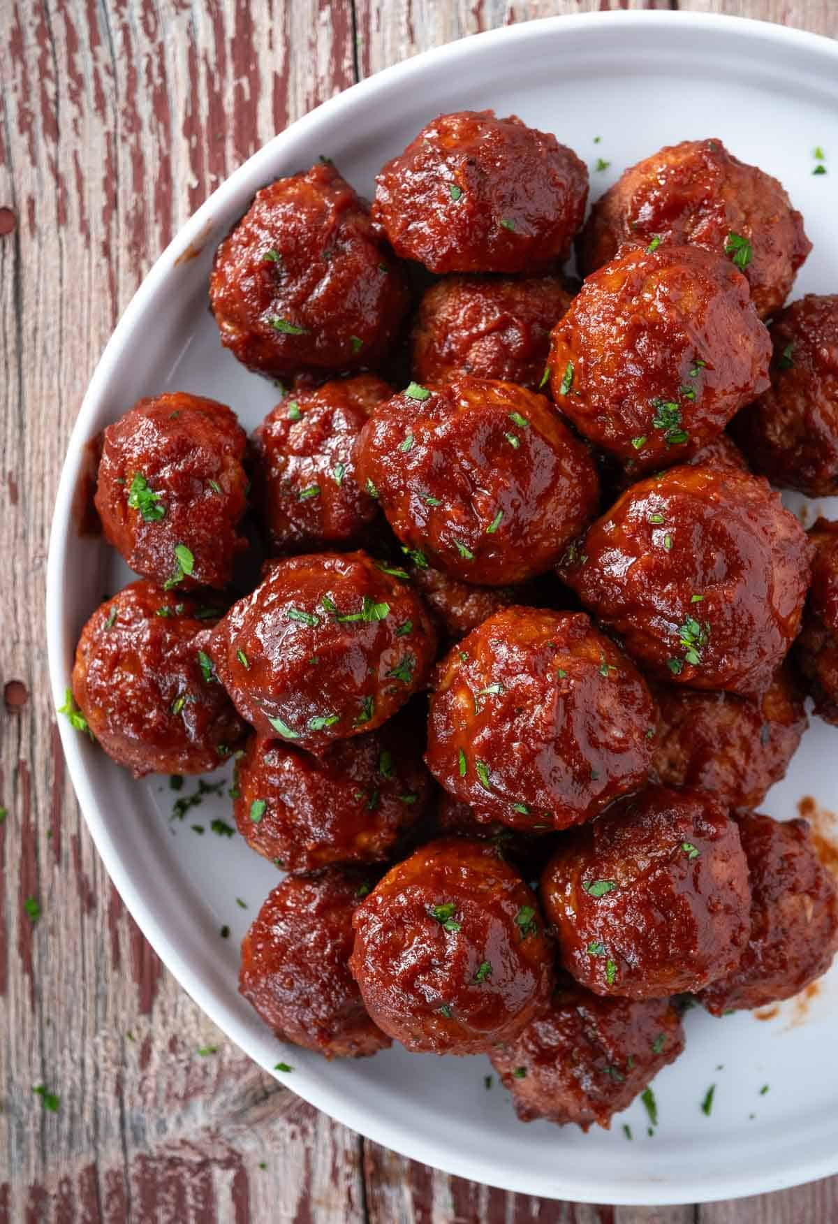BBQ turkey meatballs that are on a plate with a red wine BBQ sauce glaze.