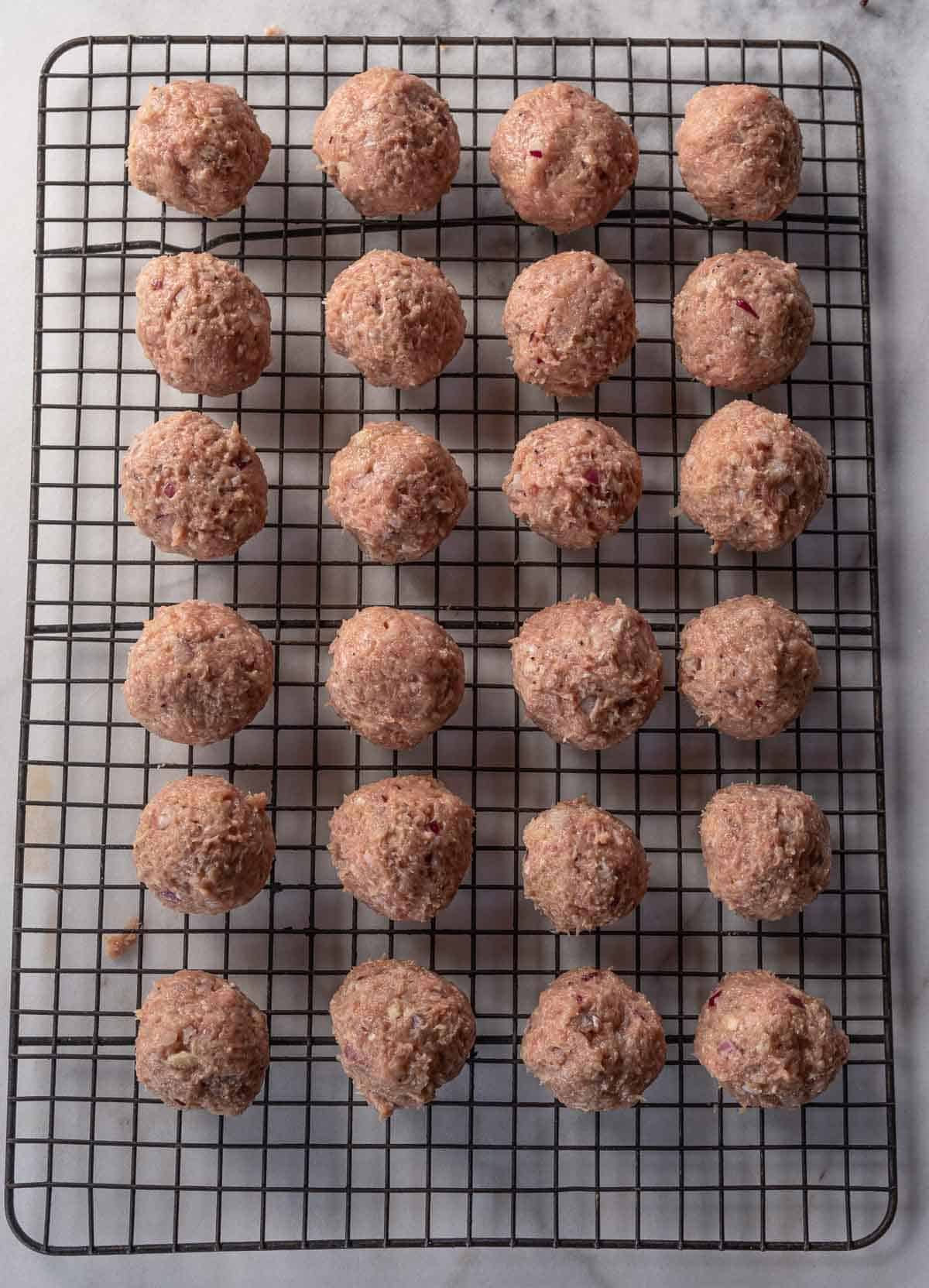 Turkey meatballs formed into golf ball sized rounds on a cookie drying rack before going on the smoker.