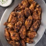 Dry Rub Chicken Wings on a silver platter next to a bowl of homemade ranch dressing