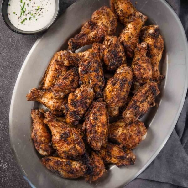 Dry Rub Chicken Wings on a platter next to a bowl of homemade ranch dressing