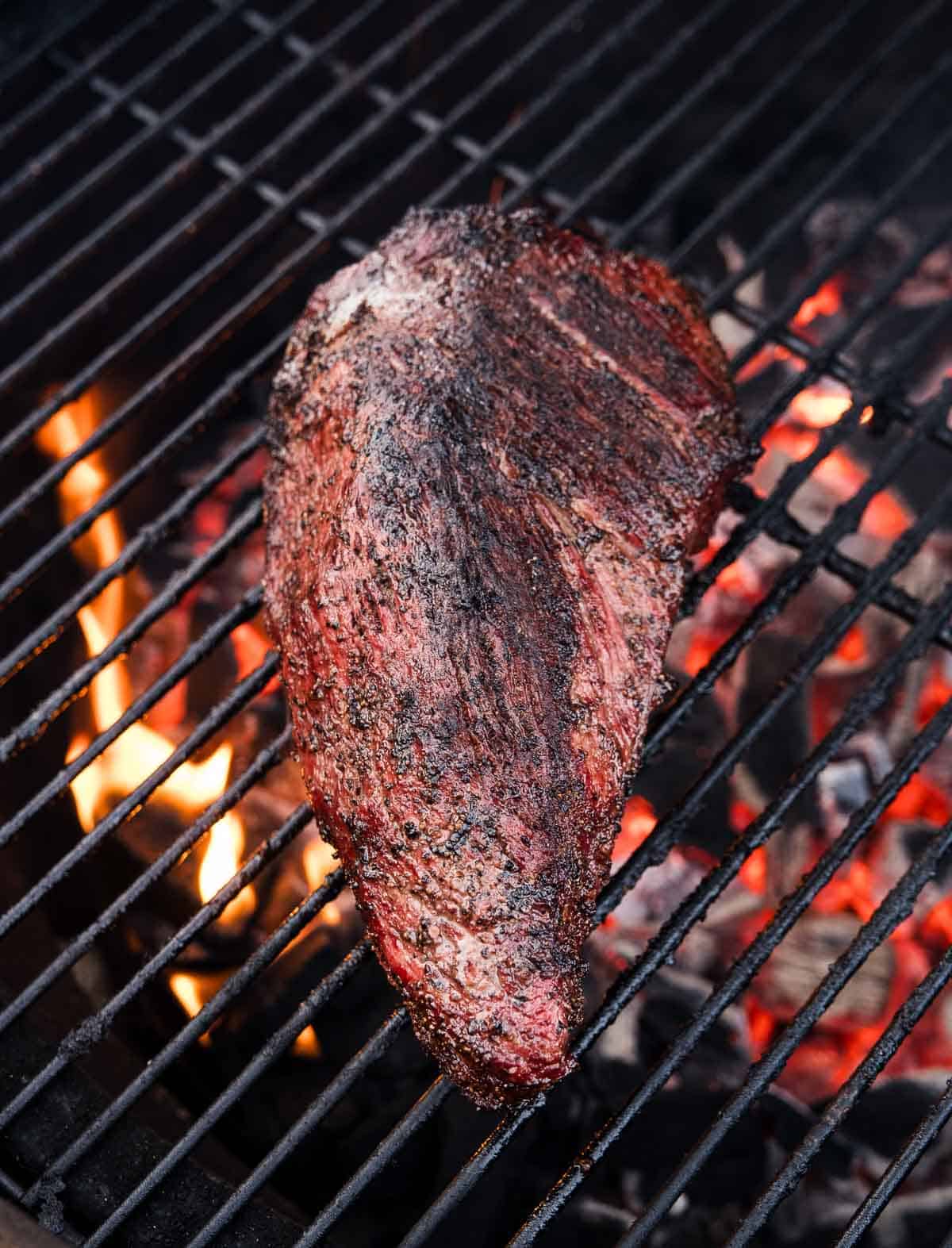 A grilled Tri Tip cooking over a hot grill