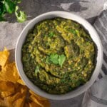 Hatch Green Chile salsa on a table with corn chips.