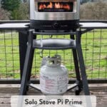Solo Stove Pi Prime with the flame on high on top of a stand on a deck.