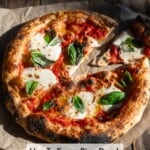 A margherita pizza that was thawed from frozen and cooked on parchment paper with one slice removed.