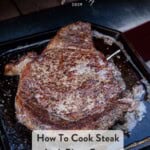 A Pinterest Pin showing a steak on a cast iron pan after it was seared and cooked in a pizza oven.