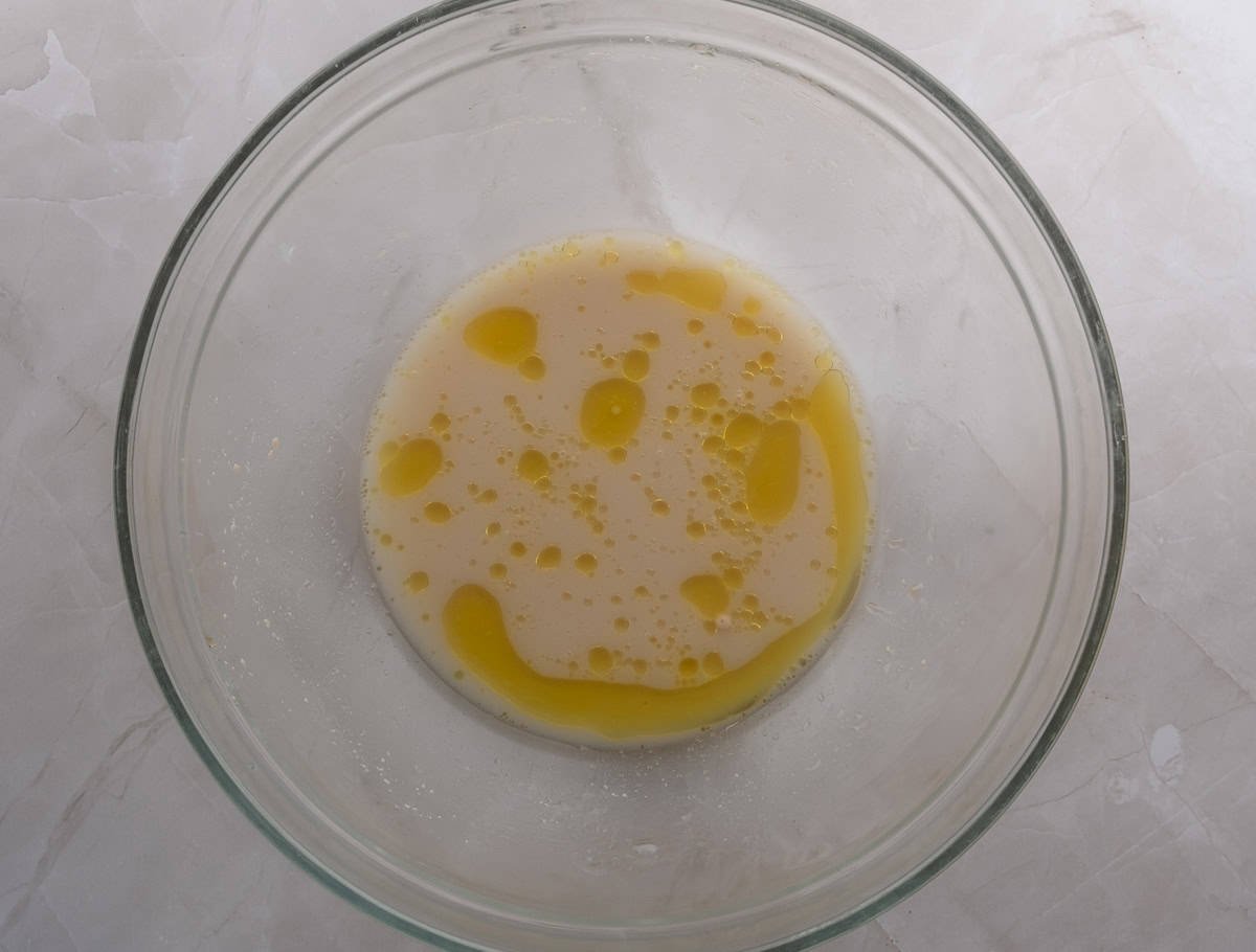 Water and yeast in a glass bowl in preparation for flour for pizza dough.