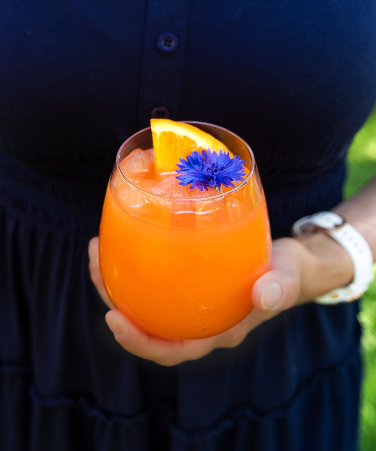 Mary from Vindulge is holding an Aperol Spritz slushie in her hands.