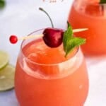 pinterest pin showing the vindulge brand and two stemless wine glasses of rose slushies garnished with cherry and mint.