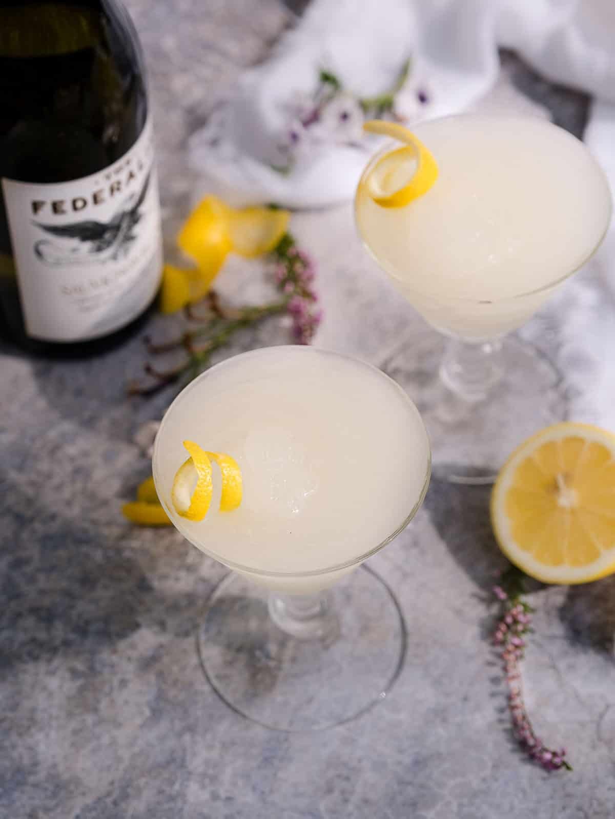 Two Kiwi 77 Sauvignon Blank Slushies on a table with a bottle of Federalist Sauvignon Blanc