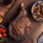 Grilled Cowboy Ribeye Steaks with Red Wine Sauce on a serving platter.