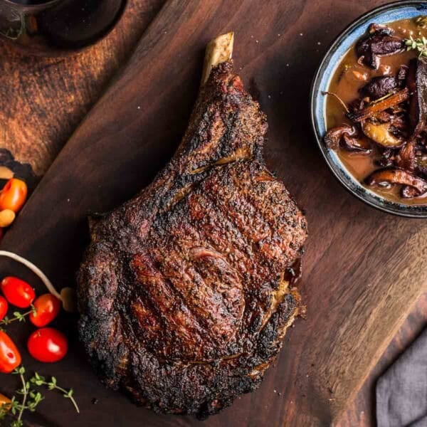 Grilled Cowboy Ribeye Steaks with Red Wine Sauce on a serving platter.