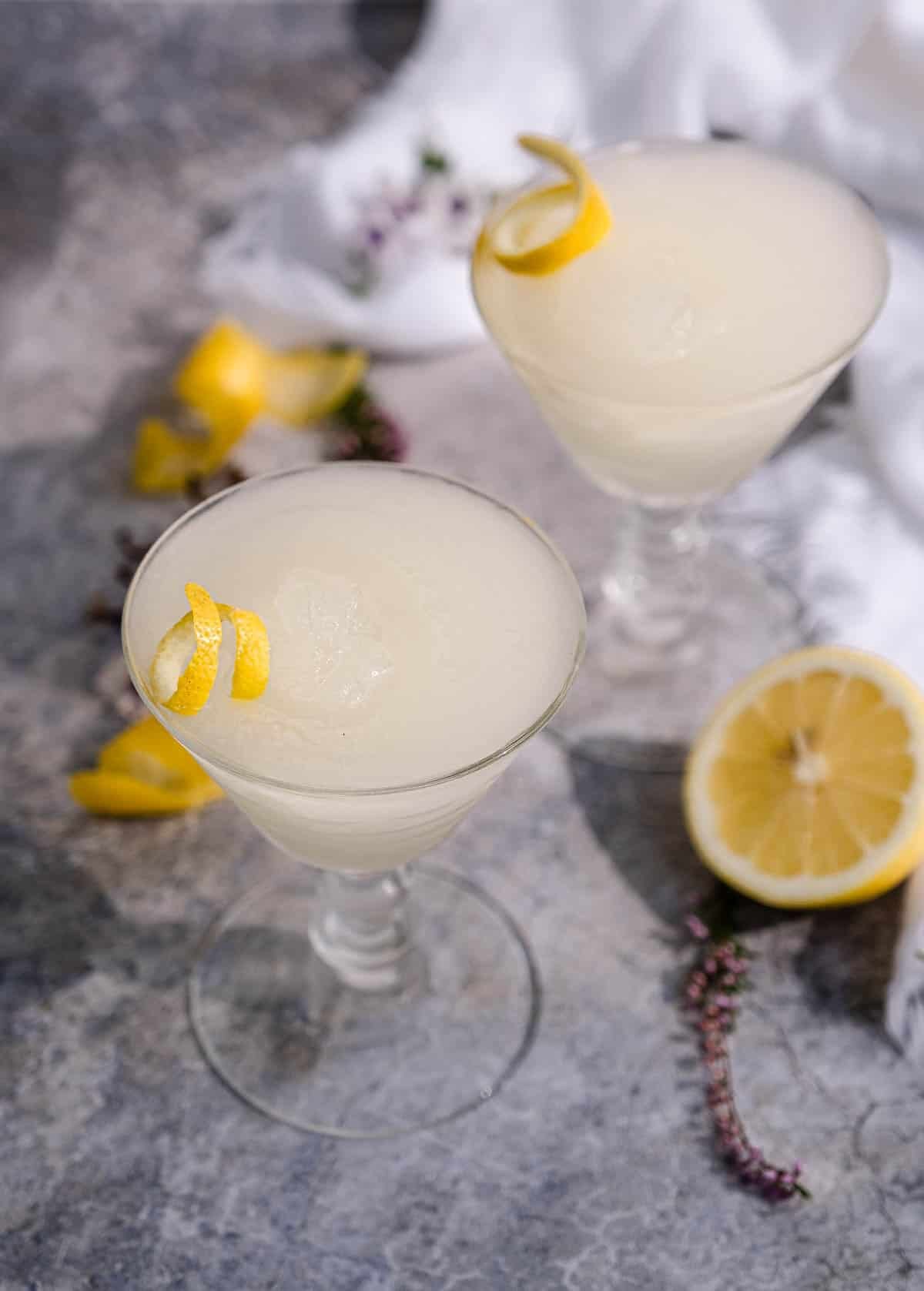 Kiwi 77 Sauvignon Blanc Slushie served in a wine glass with lemon garnish.