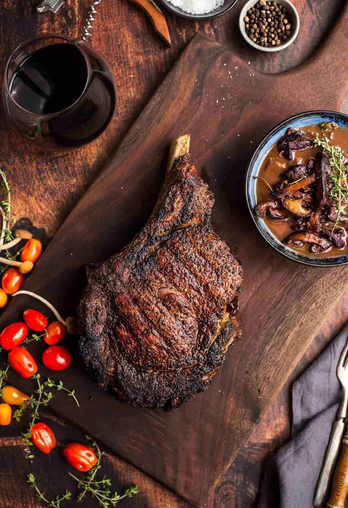 Ribeye Steak resting with a red wine mushroom sauce on the side.