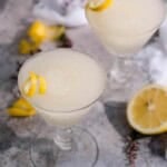 A kiwi 77 cocktail with lemon garnish.