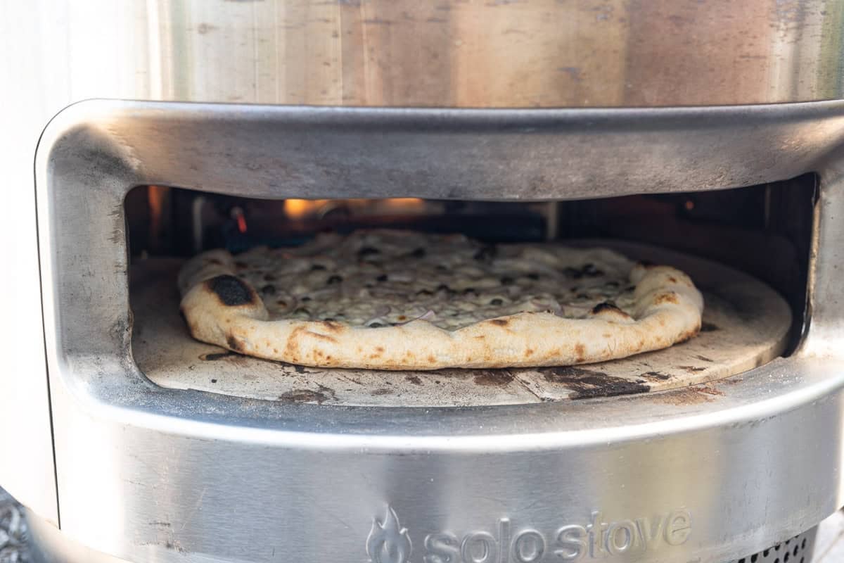 Smoked salmon pizza baking in a solo stove pizza oven.