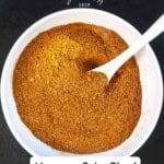 Pinterest pin showing Moroccan spice blend in a large white bowl with a white spoon.