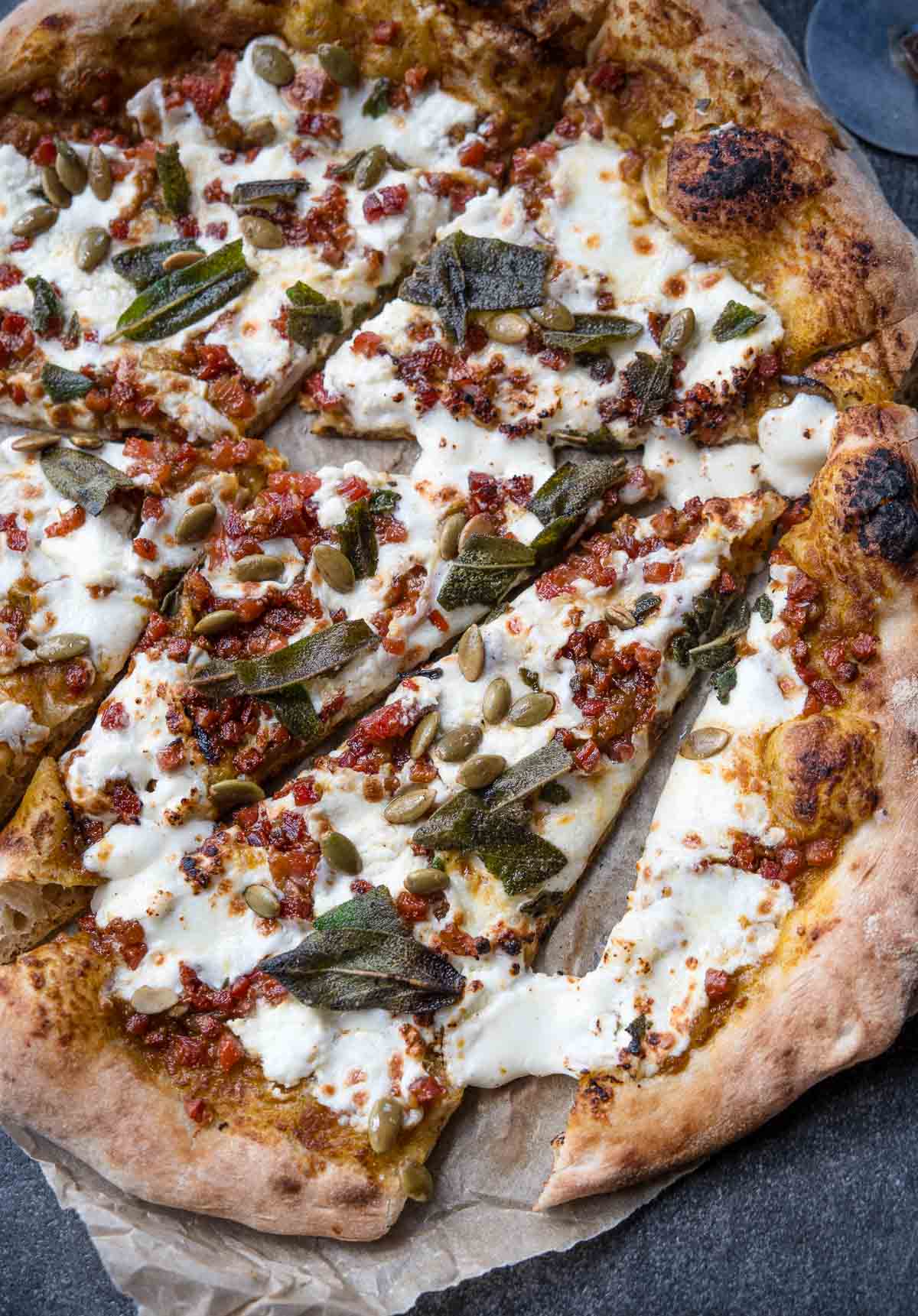 Slices of pumpkin and pancetta pizza on a serving platter.