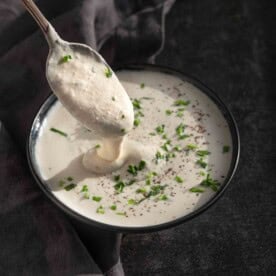 Creamy Horseradish Sauce in a bowl with a spoon dipping into it.