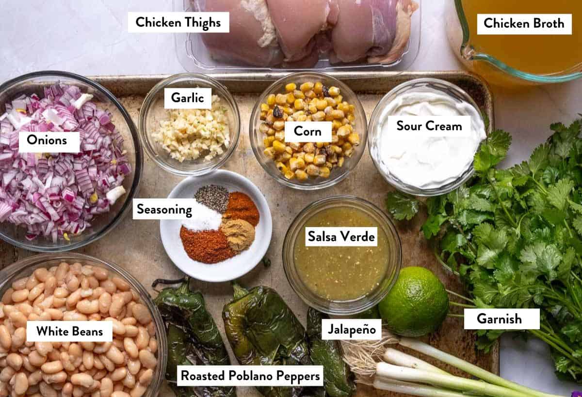 Ingredients for White Chicken Chili in bowls on a baking sheet, layered with text titles.