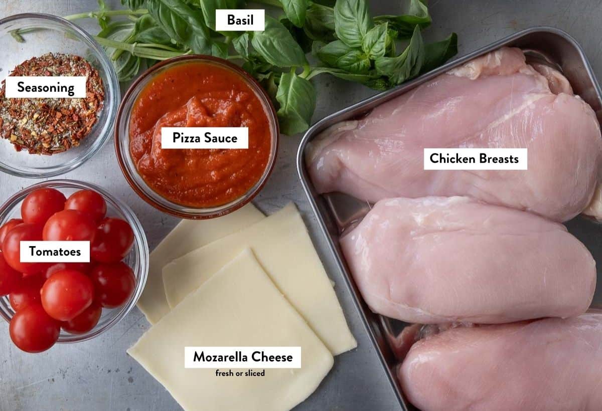 Ingredients for grilled chicken margherita on a baking sheet, labeled with ingredient names.