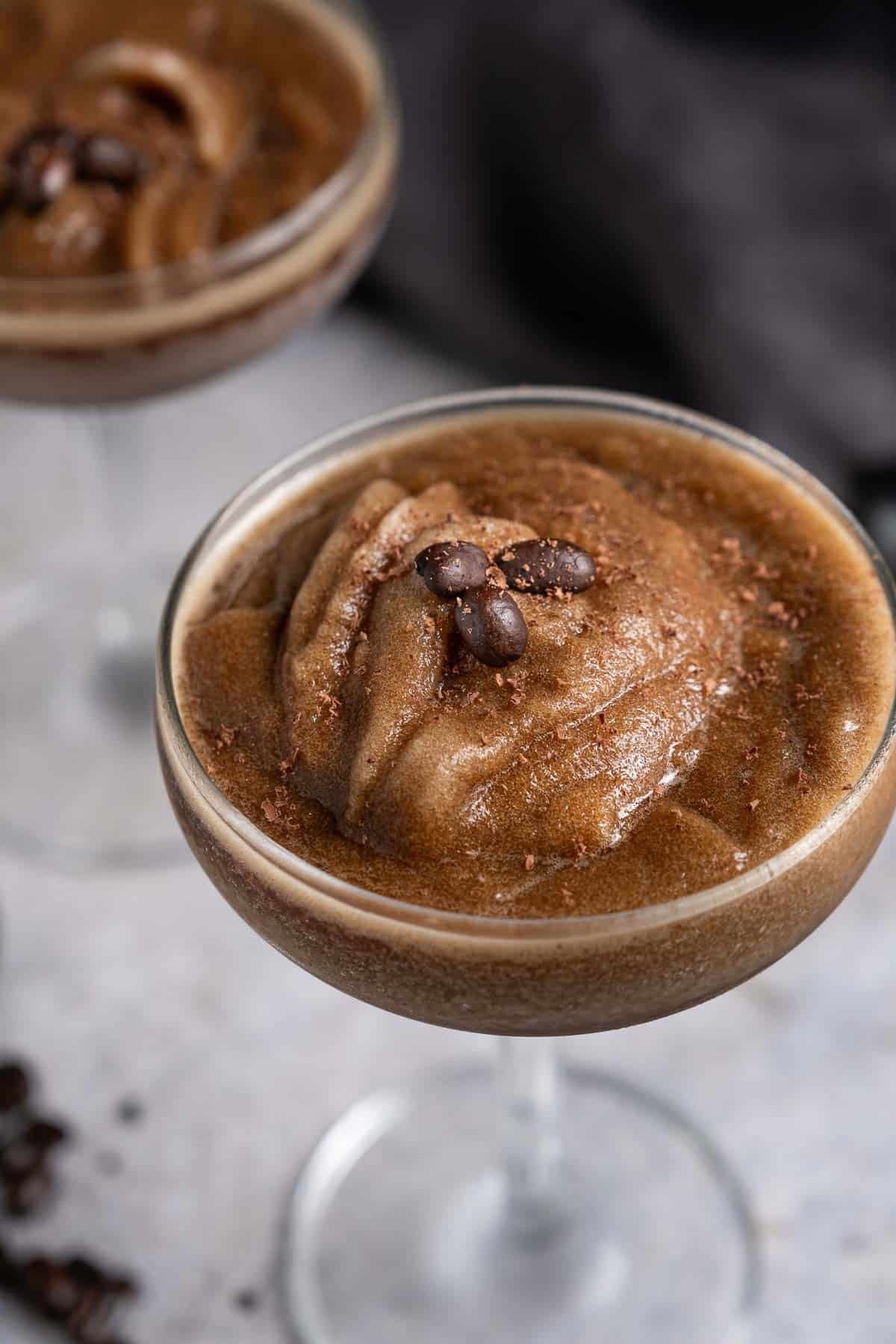 An espresso martini slushie in a serving glass.