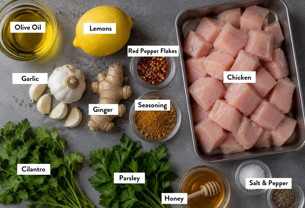 Ingredients for chicken skewers, in bowls, labeled with the names of each ingredient.