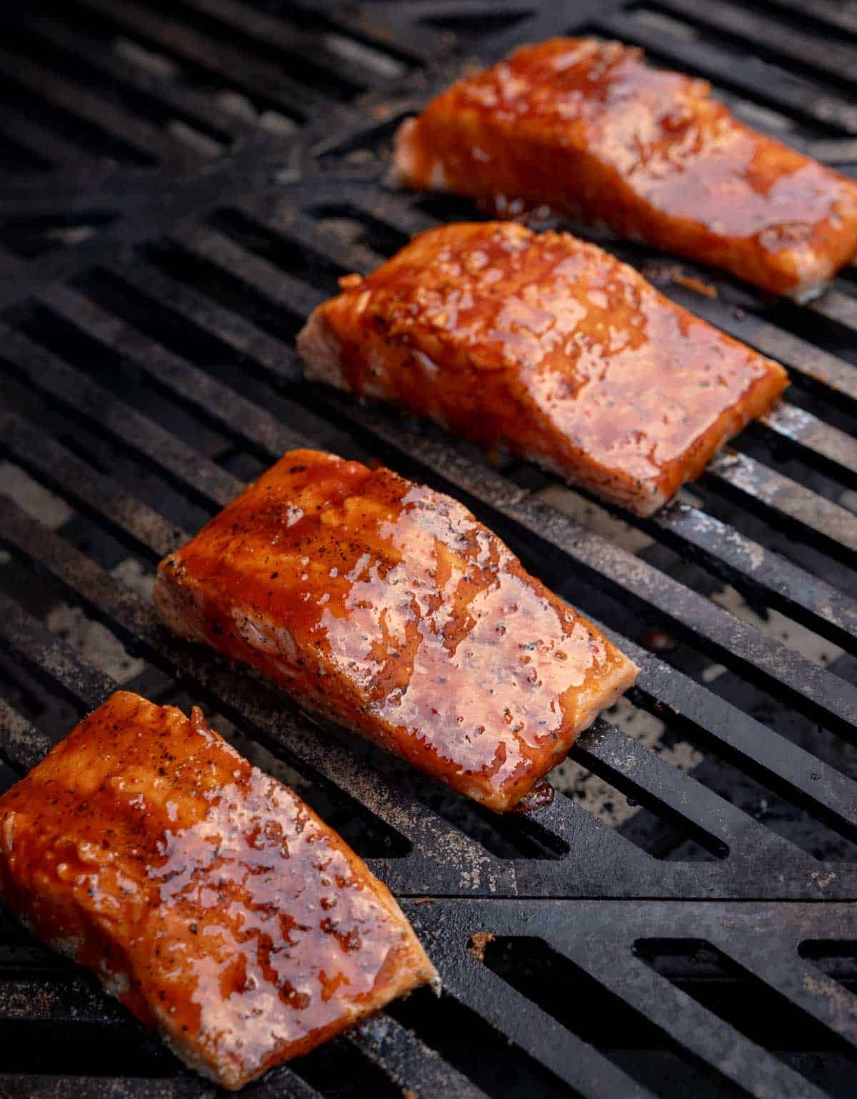 Grilled miso-glazed salmon fillets on a grill, brushed with a savory-sweet miso ginger glaze.